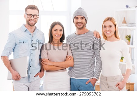 The best creative team. Group of business people in smart casual wear holding coffee cups and smiling while standing close to each other in office