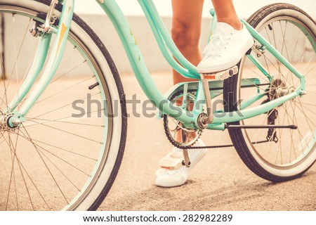 Ready to ride. Close-up of young woman holding her foot on bicycle pedal
