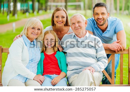 Happy family. Happy family of five people bonding to each other and smiling while sitting outdoors together