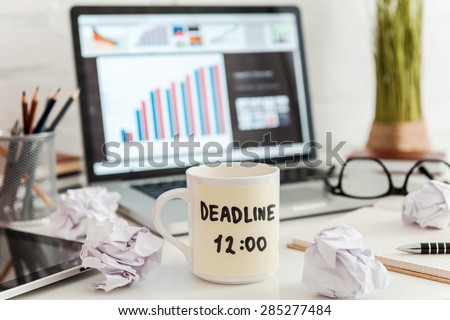 Time for action. Close-up of working place with coffee cup and adhesive note on it