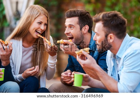 Pizza lovers. Group of playful young people eating pizza while having fun together