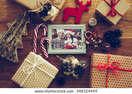 Bright memories. Top view of Christmas decorations and photograph in picture frame laying on the rustic wooden grain