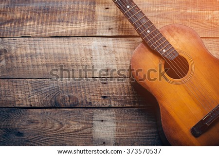 Wooden guitar. Close-up of guitar lying on vintage wood background