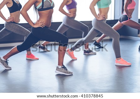 Best exercise for your booty. Side view part of young women with perfect buttocks in sportswear exercising while standing in front of window at gym