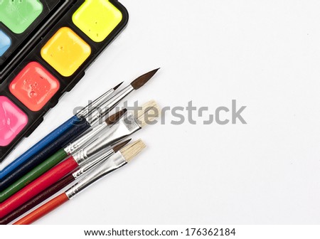 Colorful watercolor paint set with multicolored brushes isolated on white background with space for your text