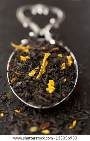 Black tea leaves with flowers on tea spoon