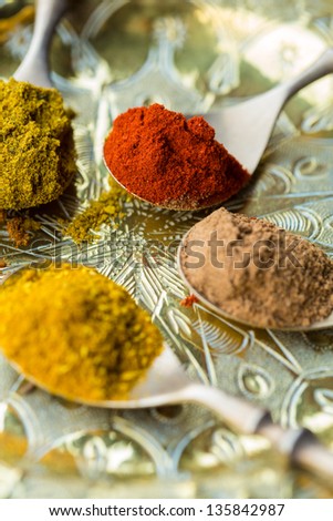 Spoons of curry powder, allspice, paprika
