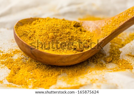curry powder in a wooden spoon