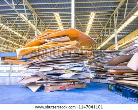 Stack of paper boxes stacked on the sheet. The paper stack is placed on a wooden pallet In the factory roof.