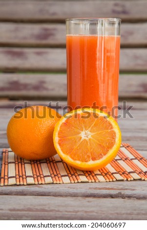 light red oranges and a glass of fresh orange juice