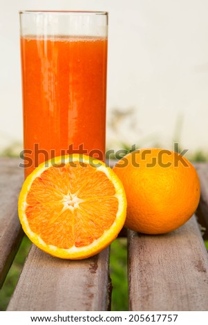 light red oranges and a glass of fresh orange juice