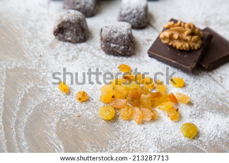 White raisins.Small chocolate biscuits,chocolate and walnuts covered by sugar powder in the background
