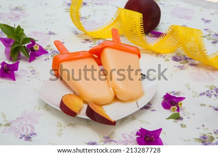 Homemade peach ice cream with pieces of fresh peach. Peaches ni the background