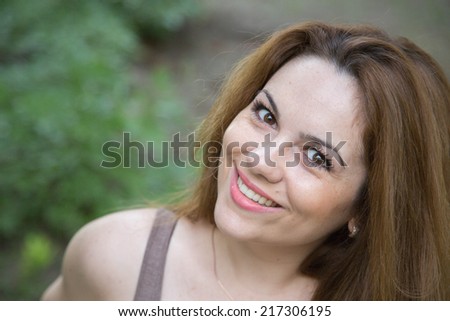 Young woman between twenty-five and thirty years old is smiling in a very charming way