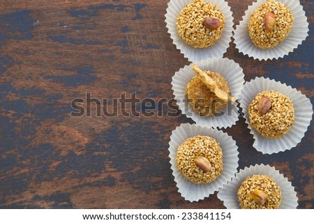 Handmade diet truffles with dried fruits and nut on an old black wooden surface. Free space for a text. Top view