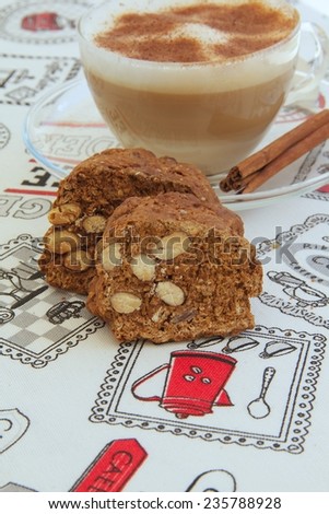 Italian biscuits with almonds- cantuccini. A cup of cappuccino in the background