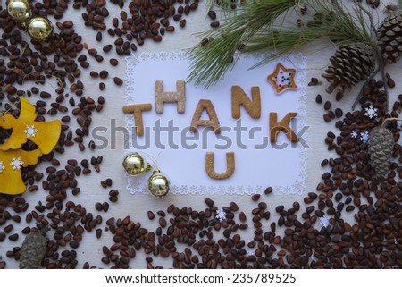 Winter holidays cedar nuts background on a wooden surface with  biscuits inscription:\