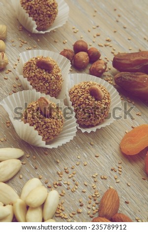 Homemade diet truffles with dried fruits and nut on wooden surface. Vintage style photo