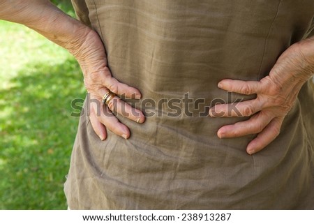 An old woman with a strong pain in low part of the back