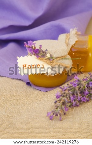 Lavender blossom honey. Lavender twigs in the background.Closeup