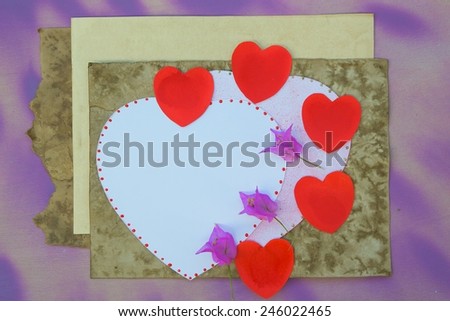 Valentines Day to do list. White and red hearts,old vintage paper, violet flowers on a violet wooden surface. Free space for a text.