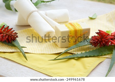 Aloe vera soap. Aloe vera and white towels on a yellow napkin in the background