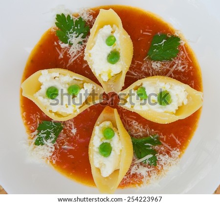Pasta with ricotta cheese, green peas and salsa on a wooden surface. Background