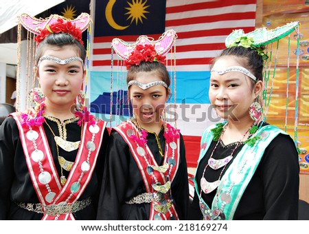 Sipitang, Sabah Malaysia.August 30, 2014 : A group of Bisaya  girls in their traditional costume smile to their guests at their booth enterance during the GaTa festival in Sipitang Sabah Malaysia.