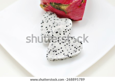 Heart-shaped dragon fruit on white plate with clean white background. Image has selective focusing and suitable for background purposes only.