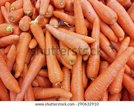 Slightly blur image of fresh carrots on supermarket display rack. Image contains visible noise and blurry due to selective focusing, not suitable for single and for background purpose only.