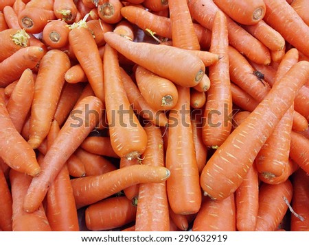 Slightly blur image of fresh carrots on supermarket display rack. Image contains visible noise and blurry due to selective focusing, not suitable for single and for background purpose only.