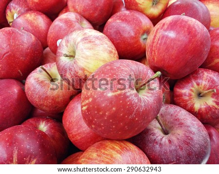 Slightly blur image of red apples on supermarket display rack. Image contains visible noise and blurry due to selective focusing, not suitable for single and for background purpose only.