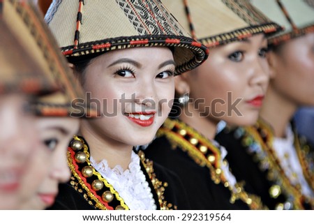 Kota Kinabalu, Sabah Malaysia.May 30, 2015 : Kadazan papar ladies in elaborated  traditional costumes look on during Pesta Kaamatan or Harvest Festival in Sabah Borneo. Image has shadow from ights.