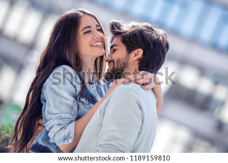 Couple in love.Happy romantic people on street.Portrait of smiling young man and woman having fun,hugging and enjoying each other outdoors.