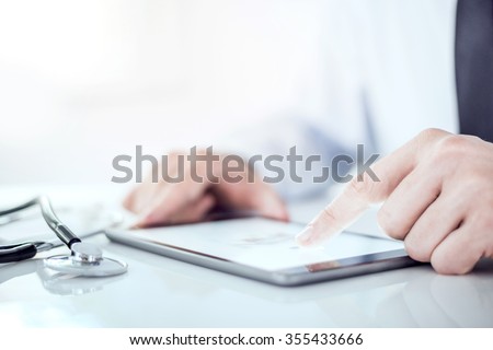 Cropped image of a doctor working on his digital tablet.He is showing digital tablet with blank screen