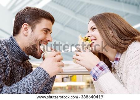 Couple looking at each other while eating fast food