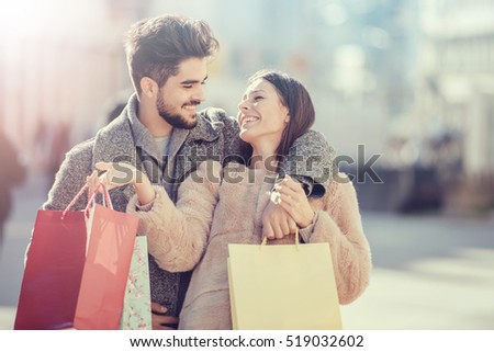 Young happy couple with shopping bags in the city.