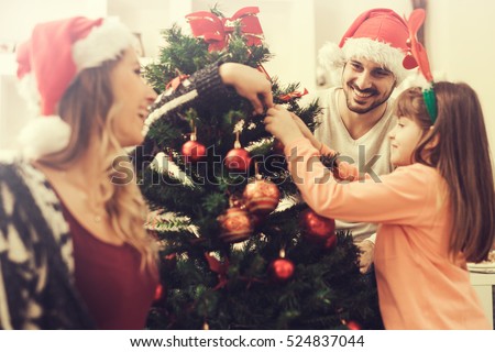 Christmas photo of a happy family around a decorated Christmas tree.