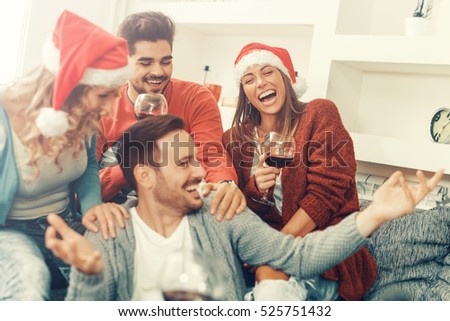 Group of friends celebrating Christmas at home, they are having fun.
