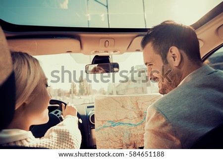 Smiling man and woman using map on roadtrip.Leisure,road trip, travel and people concept.