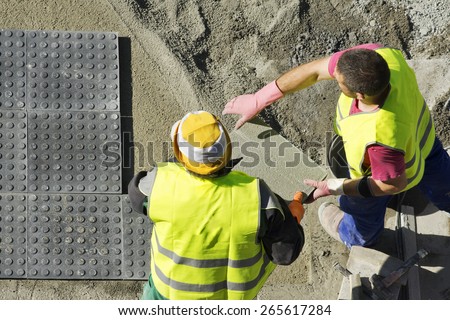 street construction workers repairing sidewalks in the city