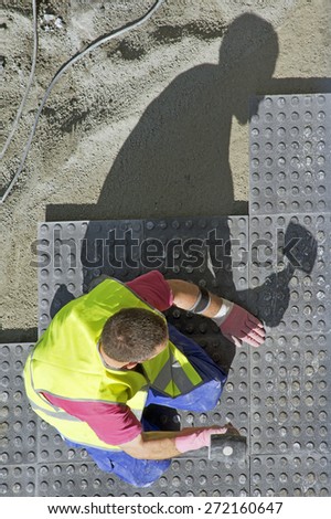 street  construction worker repairing sidewalks and pipelines in the city