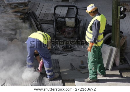 street worker repairing sidewalks and pipelines in the city