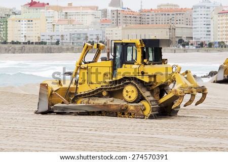 yellows excavators on the city  beach working sand moving in Corunna Spain