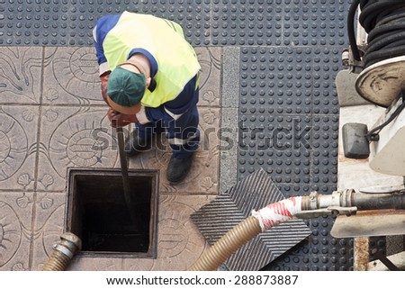 utilities workers moves the manhole cover to cleaning the sewer line for clogs