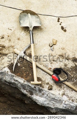 pick, shovel and  protective ear muffs to repair the sidewalks in the street city