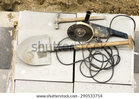 hammer drill, pick, shovel and electric grinder to repair the tiles  in the sidewalk