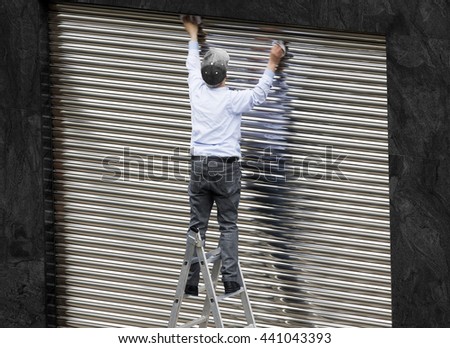old  man working cleaning metal shutter door  without safety equipment  in  danger   in  metal ladder