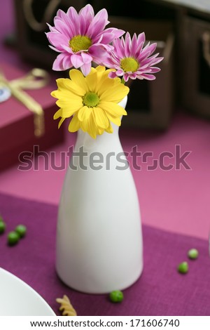 white vase with flowers on the table