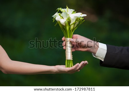 bride and groom holding a wedding bouquet of callas
